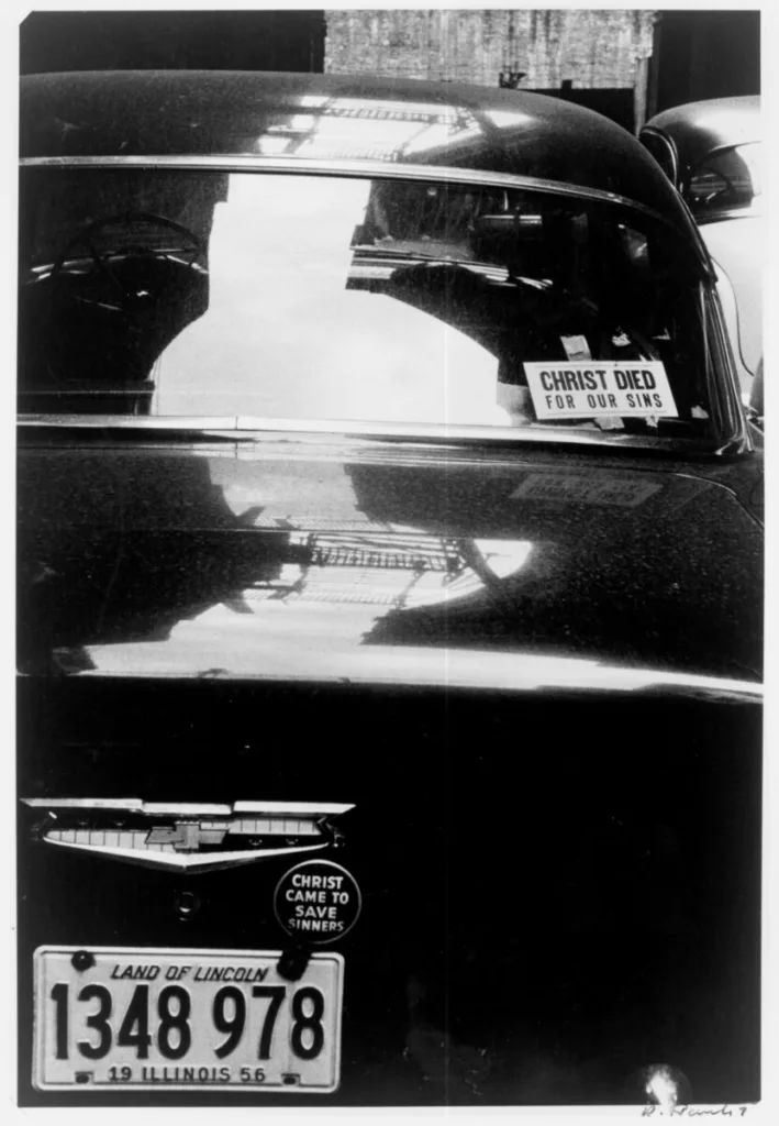 Robert Frank's 1956 image of a "CHRIST DIED FOR OUR SINS" placard on a Chevrolet in Chicago.