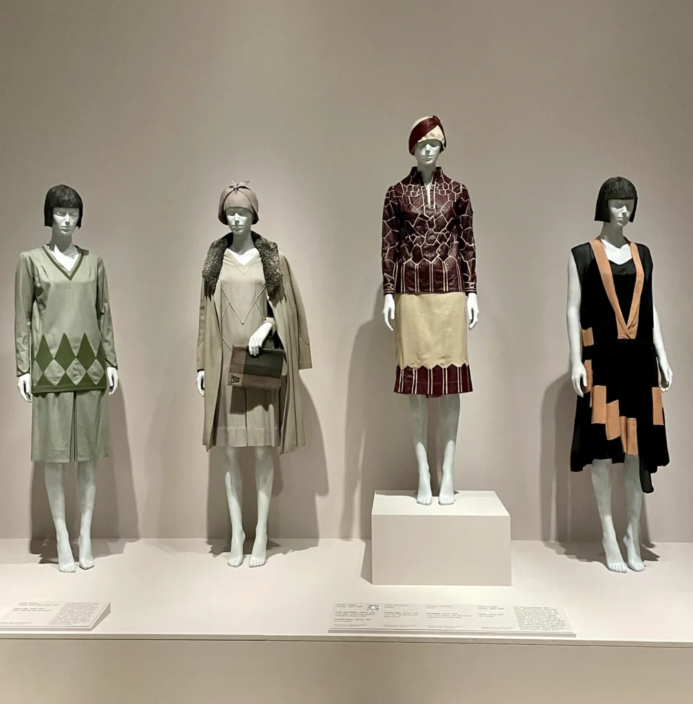 An array of women's sportswear on display at "Roaring: Art, Fashion, and the Automobile in France, 1918–1939."