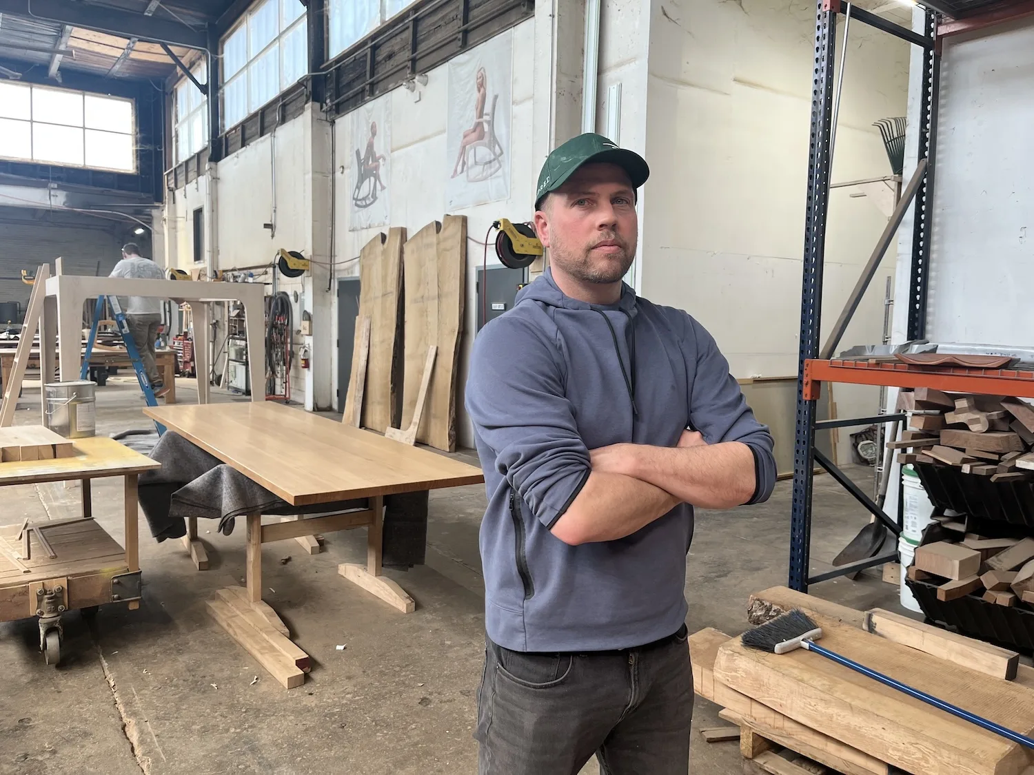 Martin Goebel stands in his factory with his arms crossed.
