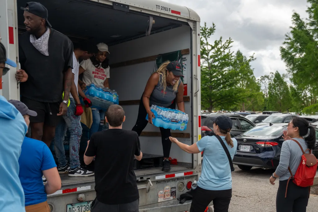 A woman unloads water from a truck.