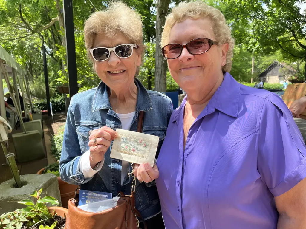 Sisters Chris and Lynn show off their grandmother's World's Fair era handkerchief at the taping of Antiques Road Show on May 13, 2025.