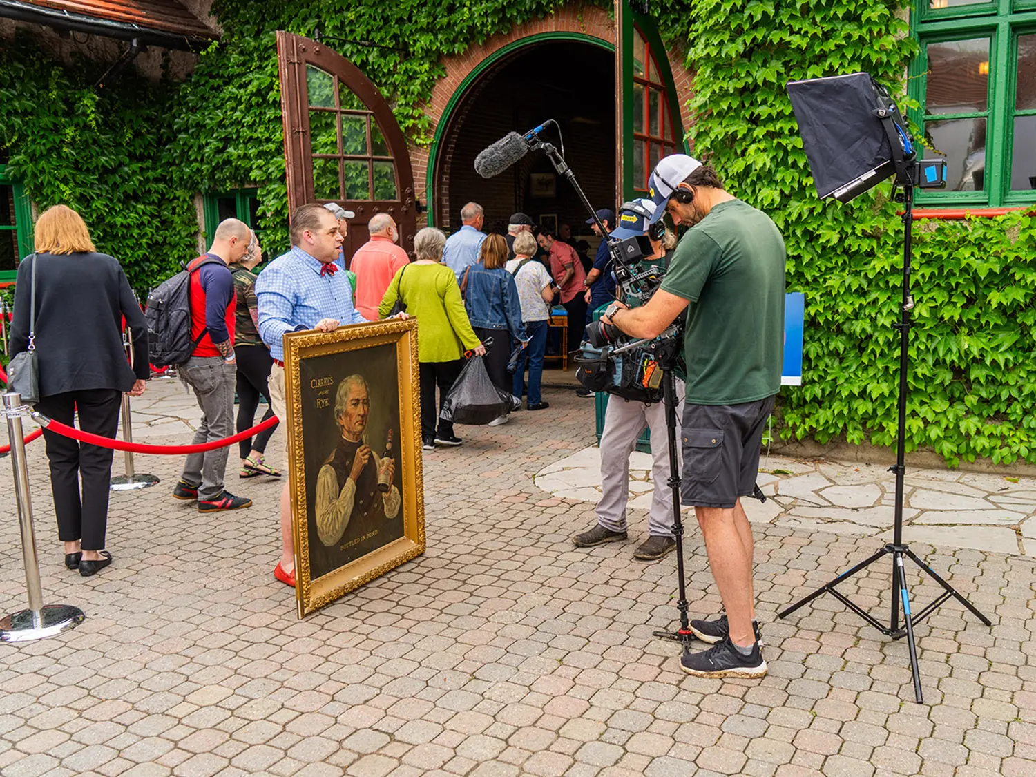 A man shows off an antique painting as he waits in line to get it appraised by the Antiques Roadshow at Grant's Farm in St. Louis.