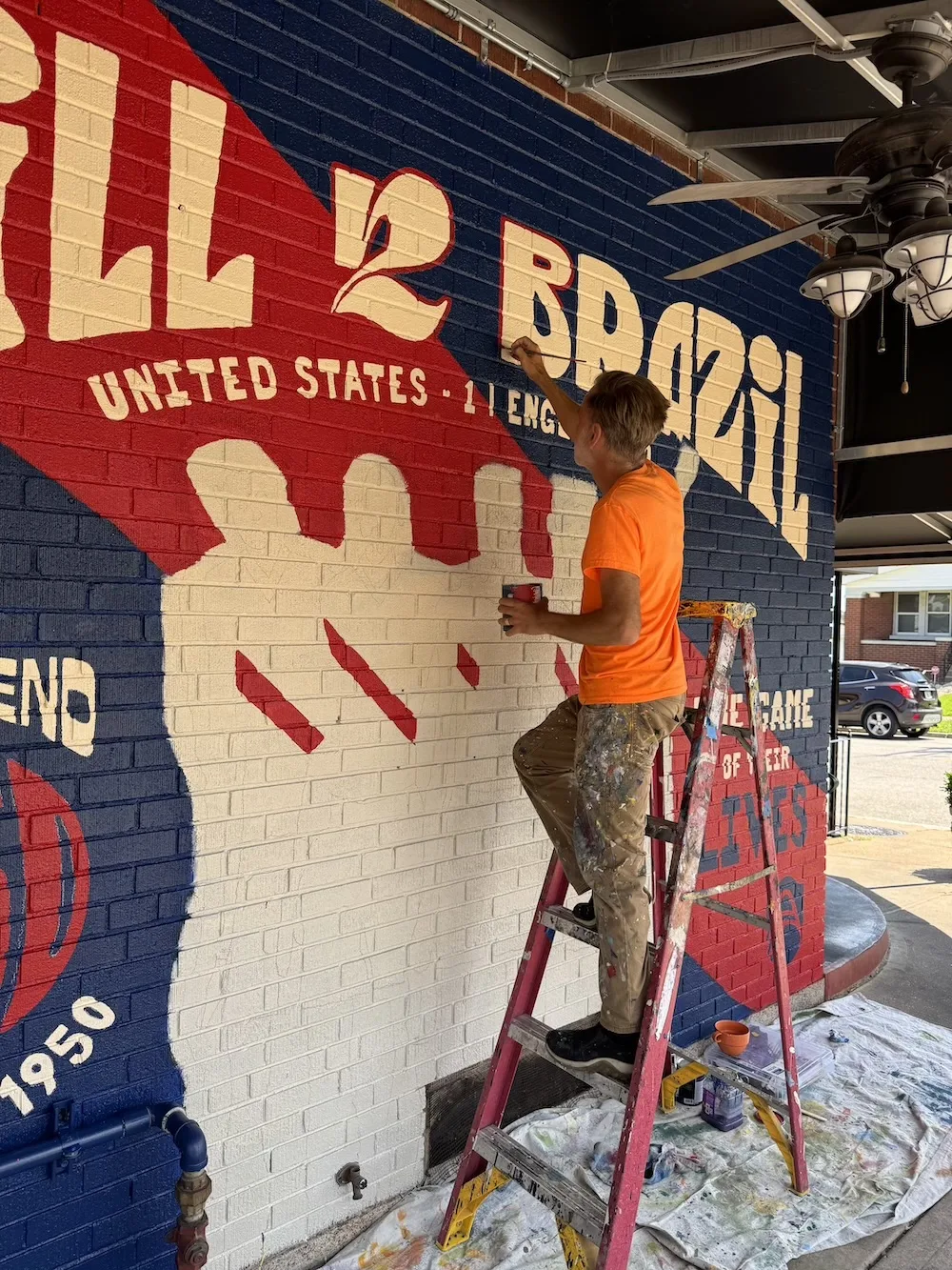 Scott Podrom paints a mural at Anthonino’s Taverna on The Hill to honor the 1950 US World Cup team.