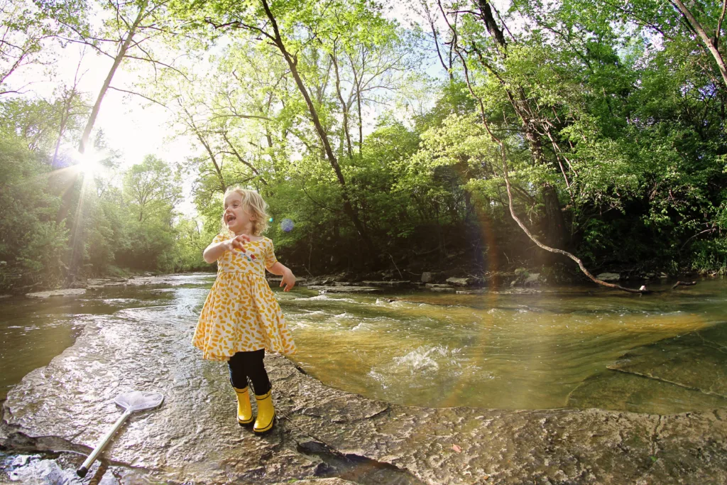 Child dances on the bank of a Missouri creek