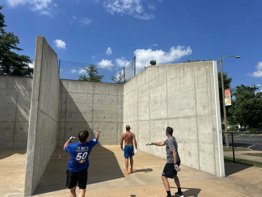 Members Mike Rogers, Matt Balcer, and Mike Benkelman play outdoor handball at Kirkwood Park.