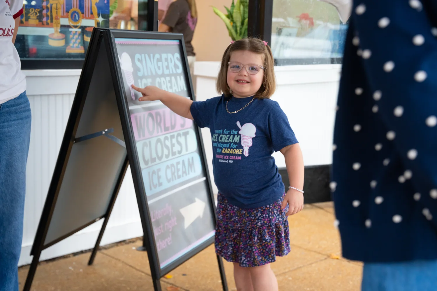 child pointing to sign at the SLM ice cream social