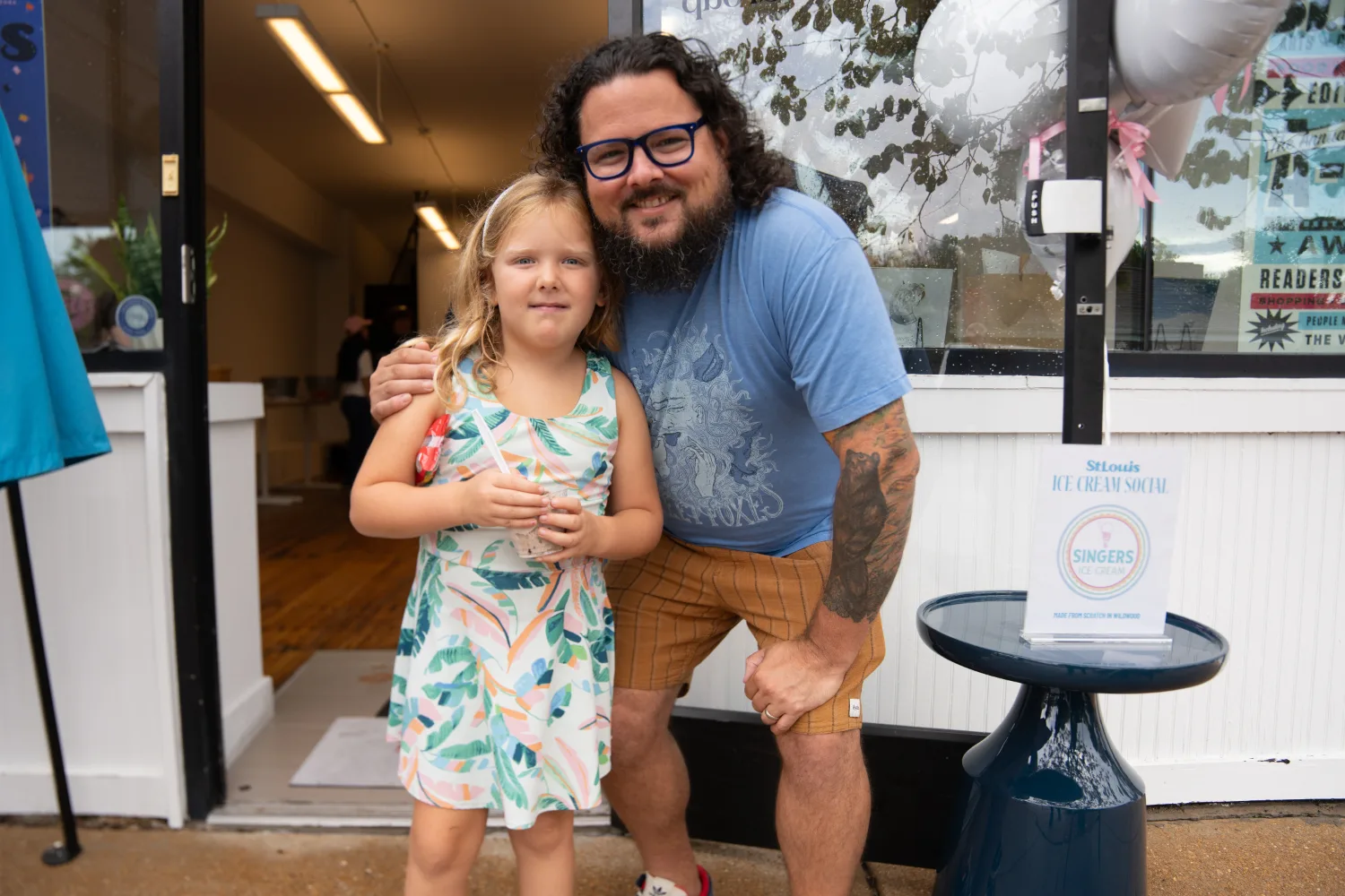 Two people posing for a picture outside of the SLM ice cream social