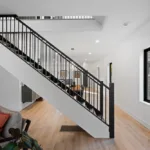 Custom staircase with black steel railing designed by Campbell House and Home.