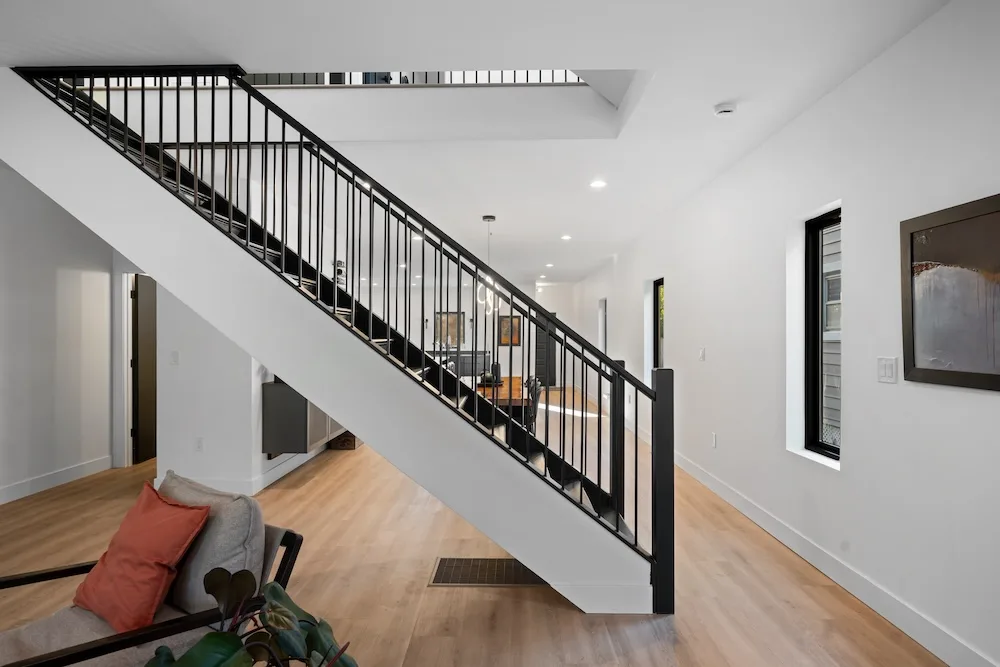 Custom staircase with black steel railing designed by Campbell House and Home.