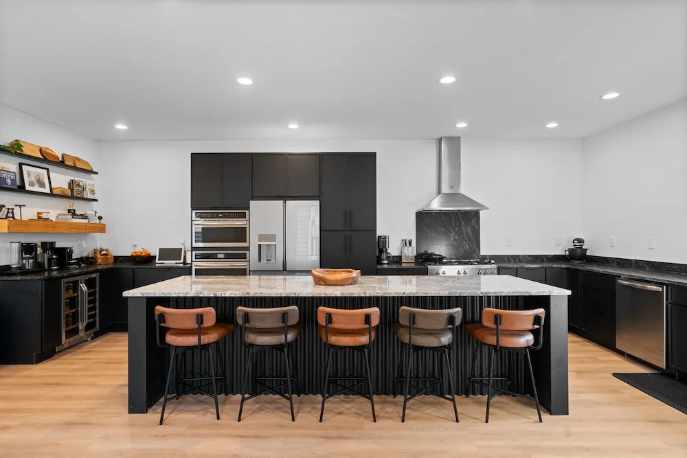 Campbell House and Home kitchen featuring black cabinetry, open shelving, fusing natural materials with modern design.