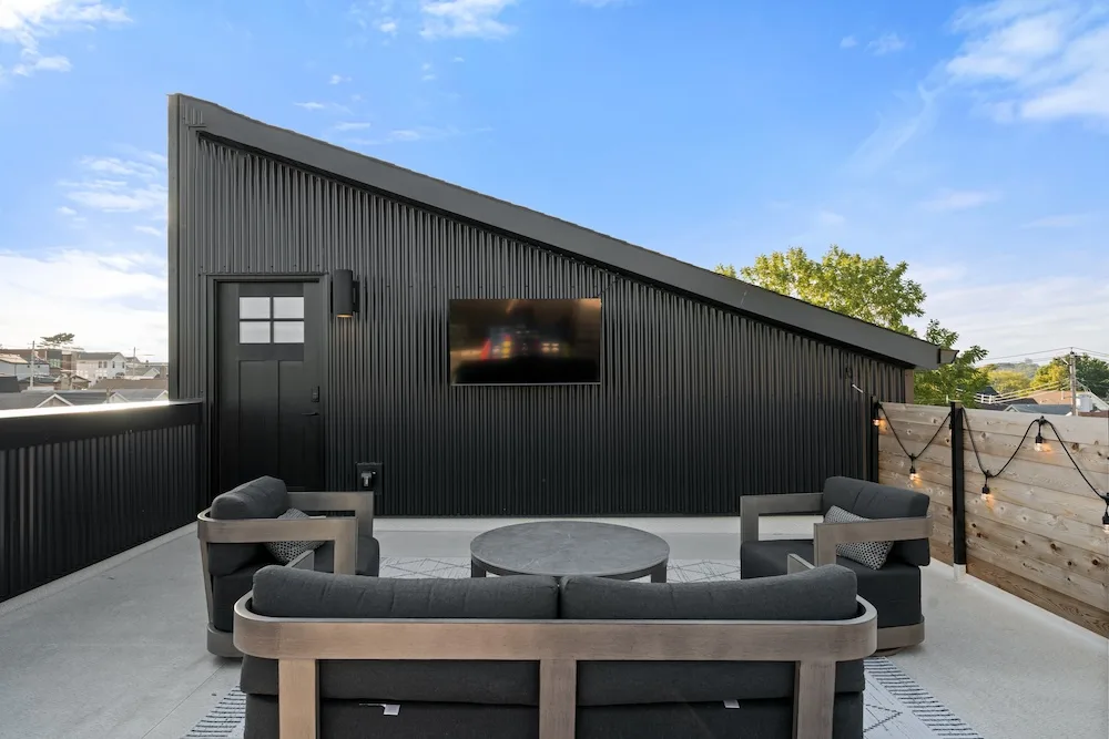 Rooftop deck designed by Campbell House and Home with modern seating and string lights.