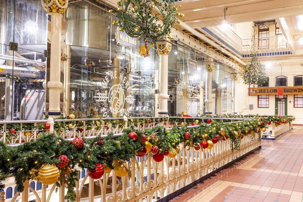 Inside the brewery, garlands of greenery and colorful ornaments line the railings around the industrial mash tanks.