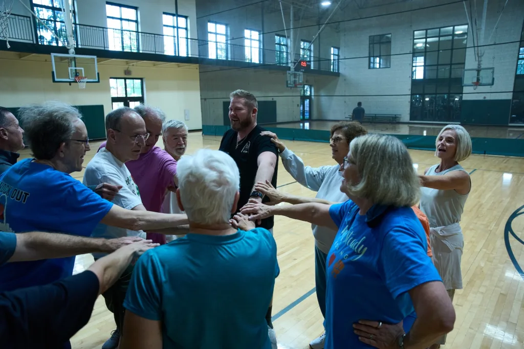 People form at a huddle at a gym.