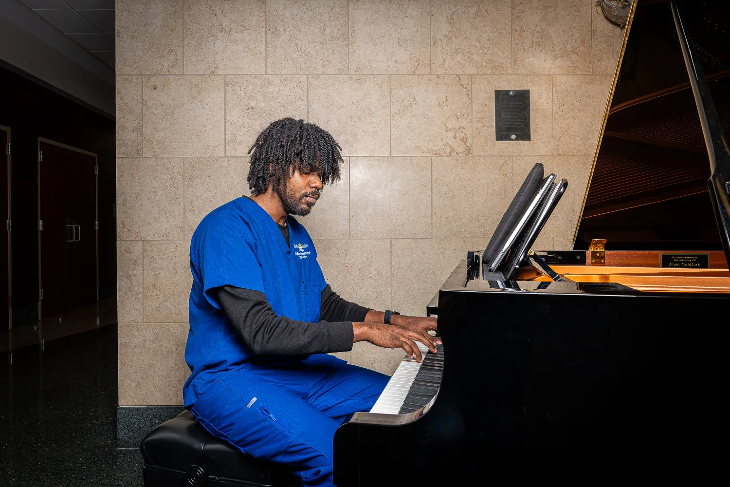 Nursing student Nicholas Murphy sits at the Goldfarb lobby piano.