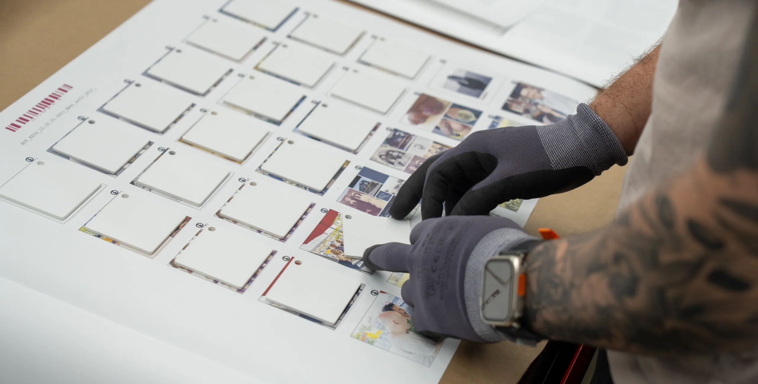 A person positioning white squares on a piece of paper.