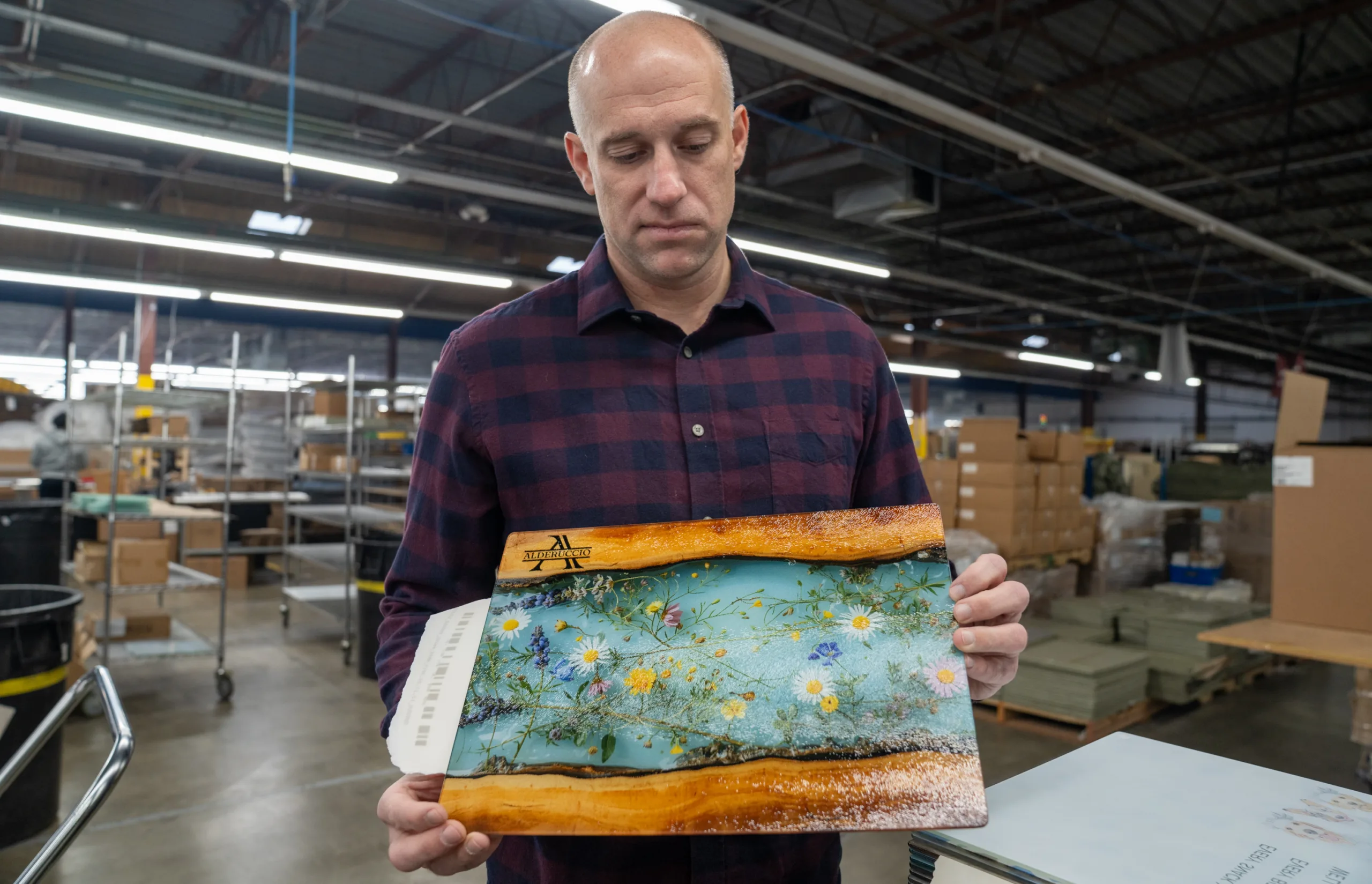 A man holding a glass cutting board
