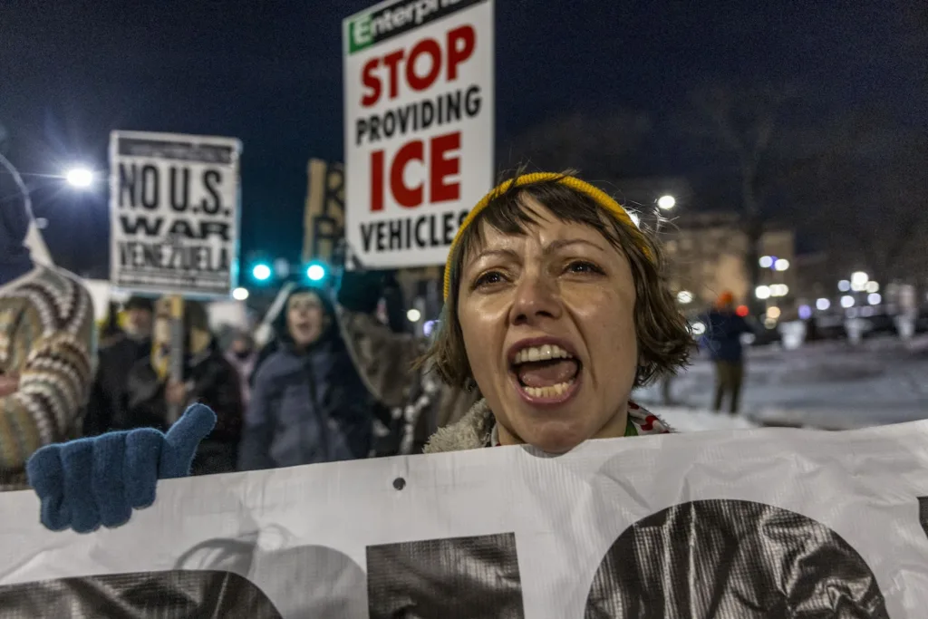Demonstrators protest ICE with signs.