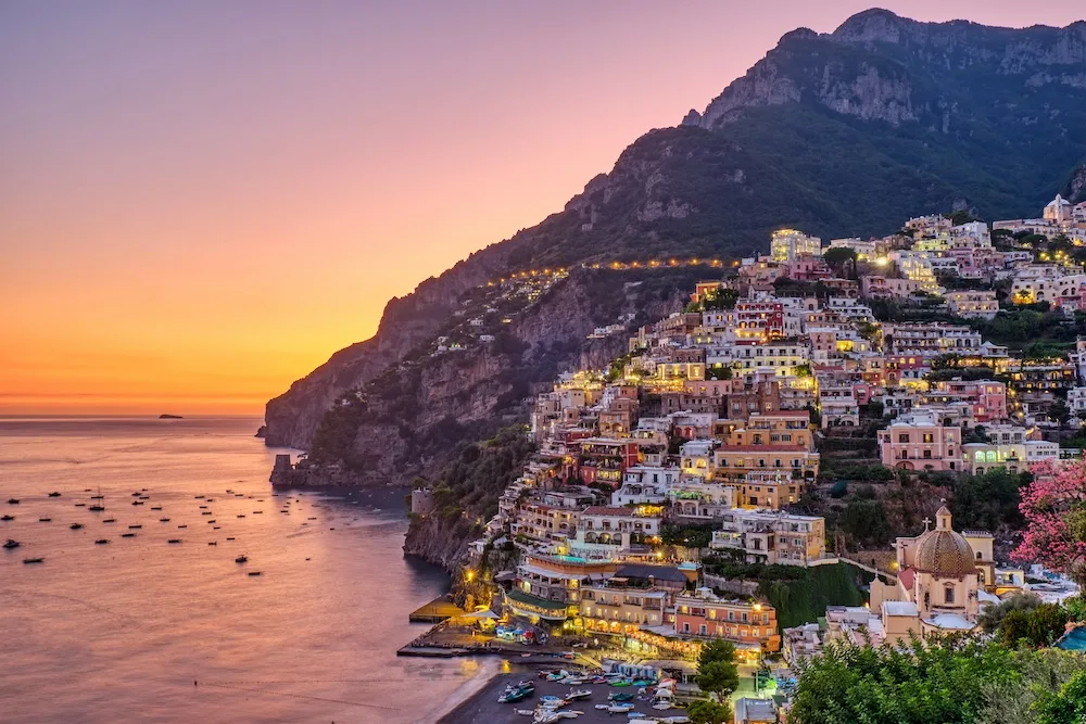 Colorful hillside buildings in Positano at sunset along Italy’s Amalfi Coast.