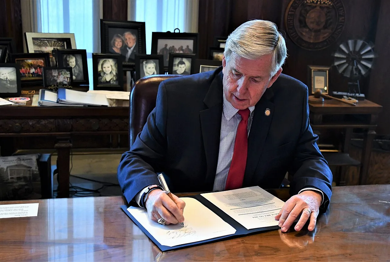 Mike Parson signing a bill.