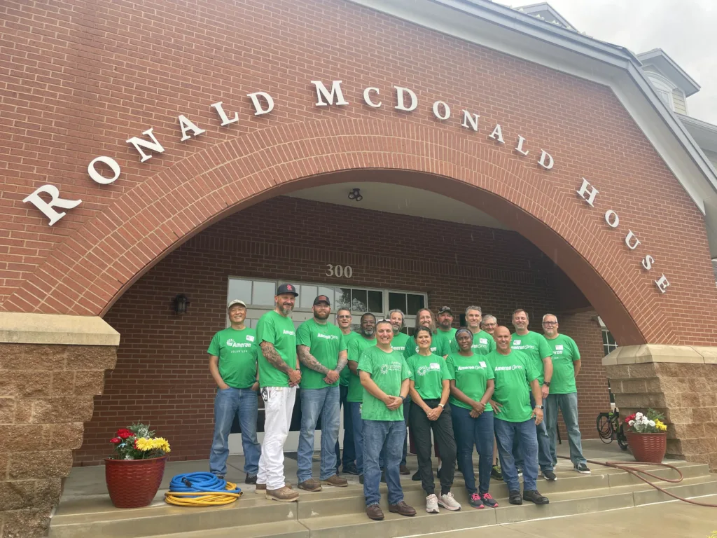 Team members pose outside Ronald McDonald House after a volunteer project.