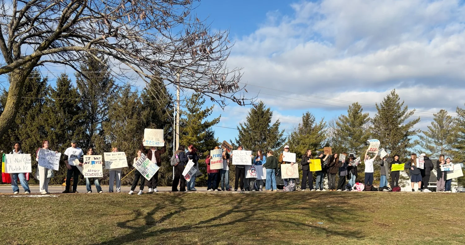 Students hold signs.