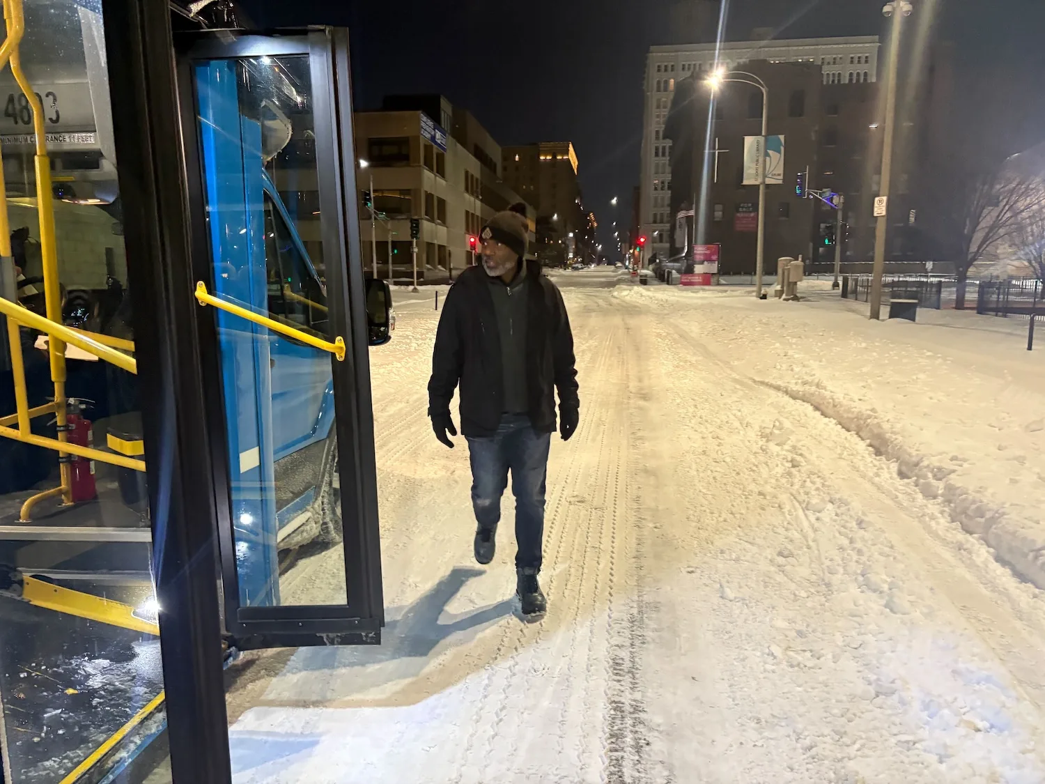 A man looks out on a snowy night.
