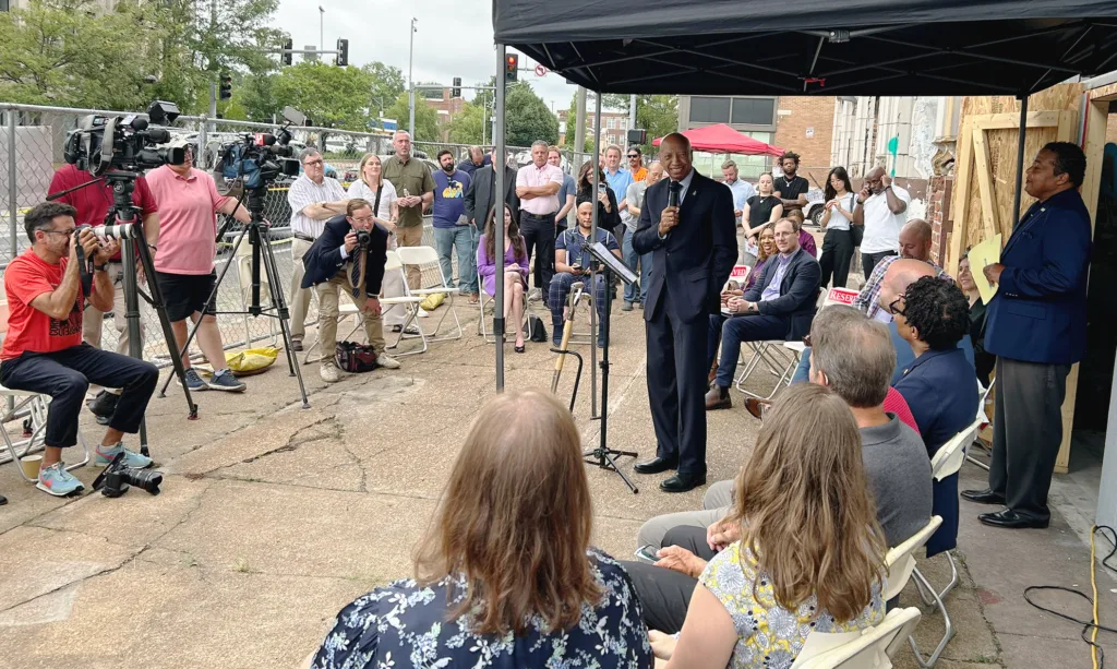 A man speaking with a microphone.