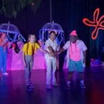 Students perform a colorful under-the-sea scene with jellyfish props during a STAGES Performing Arts Academy production.