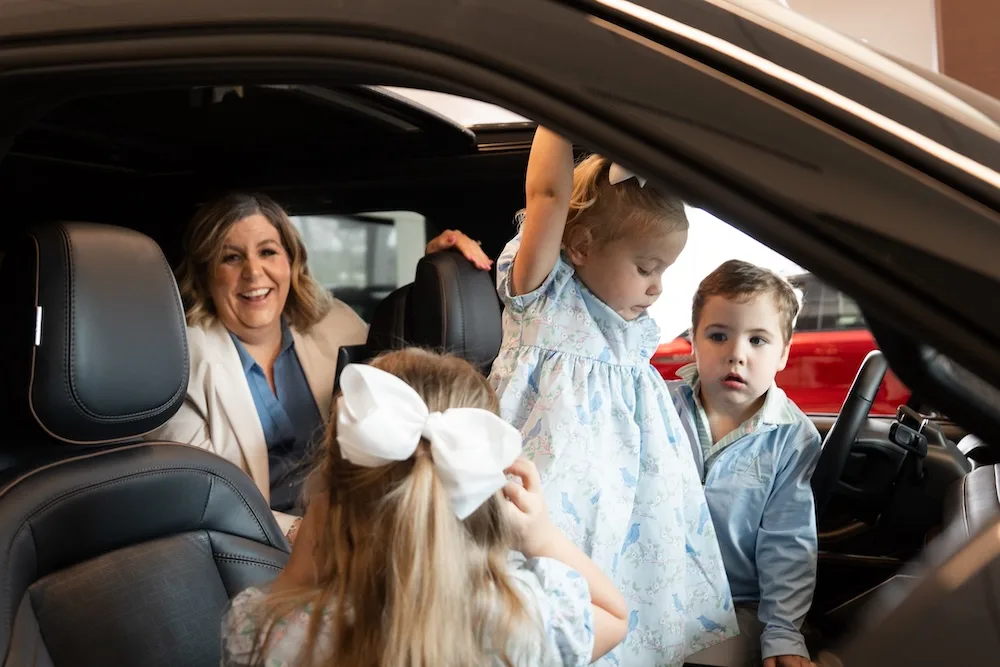 Megan Sinclair’s children explore the front seat of a showroom vehicle.