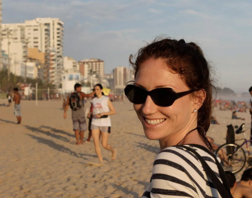 A woman on a beach wearing sunglasses.