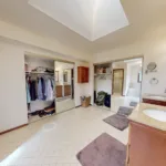 Before: The original bathroom layout featured vanities, a shower positioned off to one side, and open space through the center of the room.