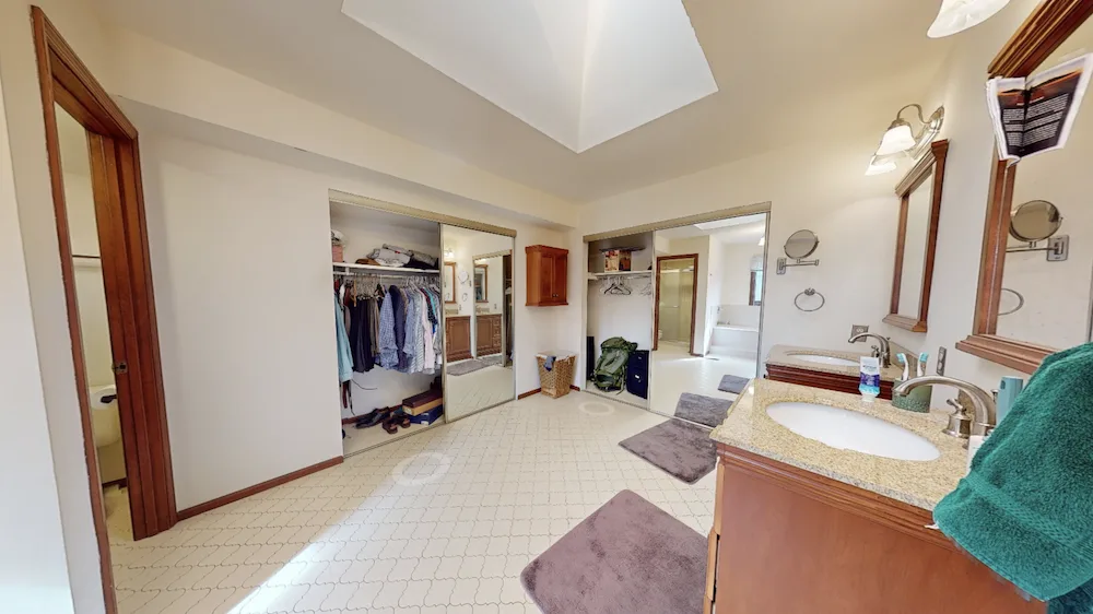 Before: The original bathroom layout featured vanities, a shower positioned off to one side, and open space through the center of the room.