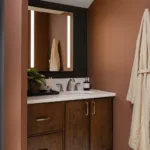 Warm wood cabinetry and integrated lighting contribute to the spa-inspired atmosphere the homeowner wanted throughout the redesigned space.