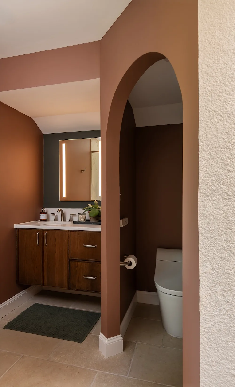 Arched walkways frame the vanity and lavatory spaces, helping the room reveal itself gradually instead of showing every feature at once.