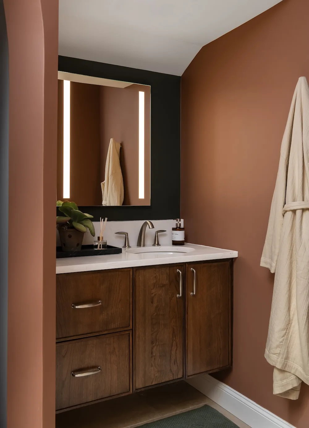 Warm wood cabinetry and integrated lighting contribute to the spa-inspired atmosphere the homeowner wanted throughout the redesigned space.