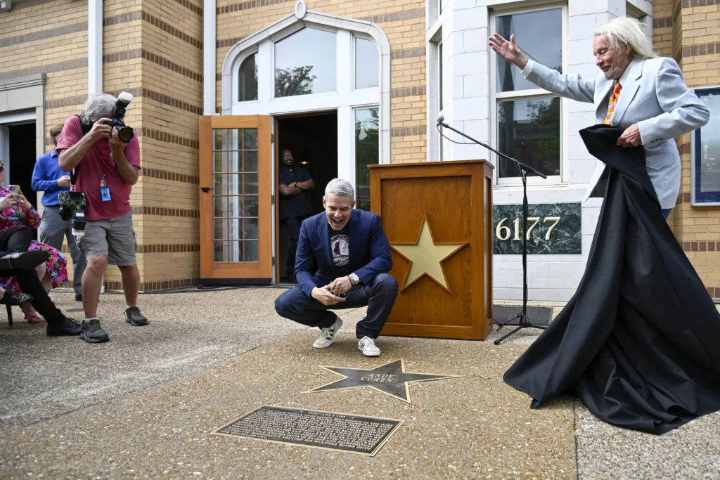 Television host Andy Cohen kneels beside his St. Louis Walk of Fame star during an unveiling ceremony in the Delmar Loop.