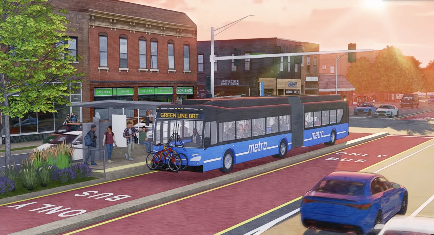 A bus runs in a protected lane, with red brick buildings behind it.