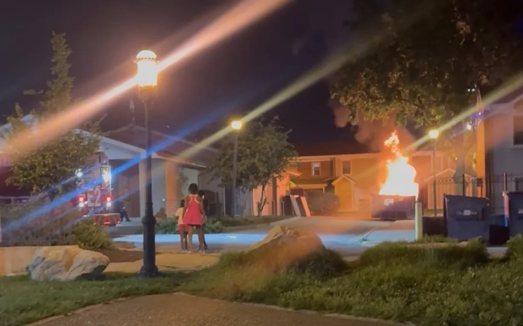 A dumpster burns.