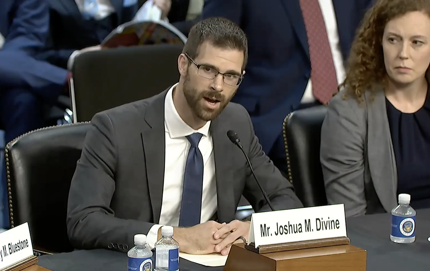 A man in a suit speaks at a congressional hearing.