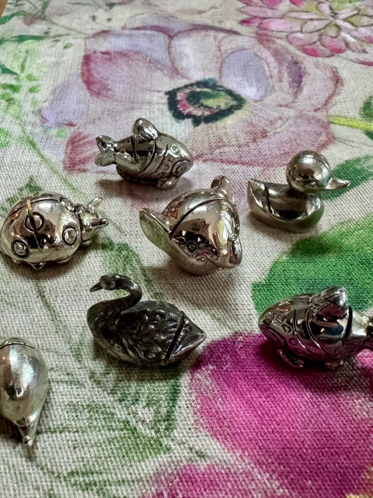 Antique silver name card holders in the shape of various animals and bugs.