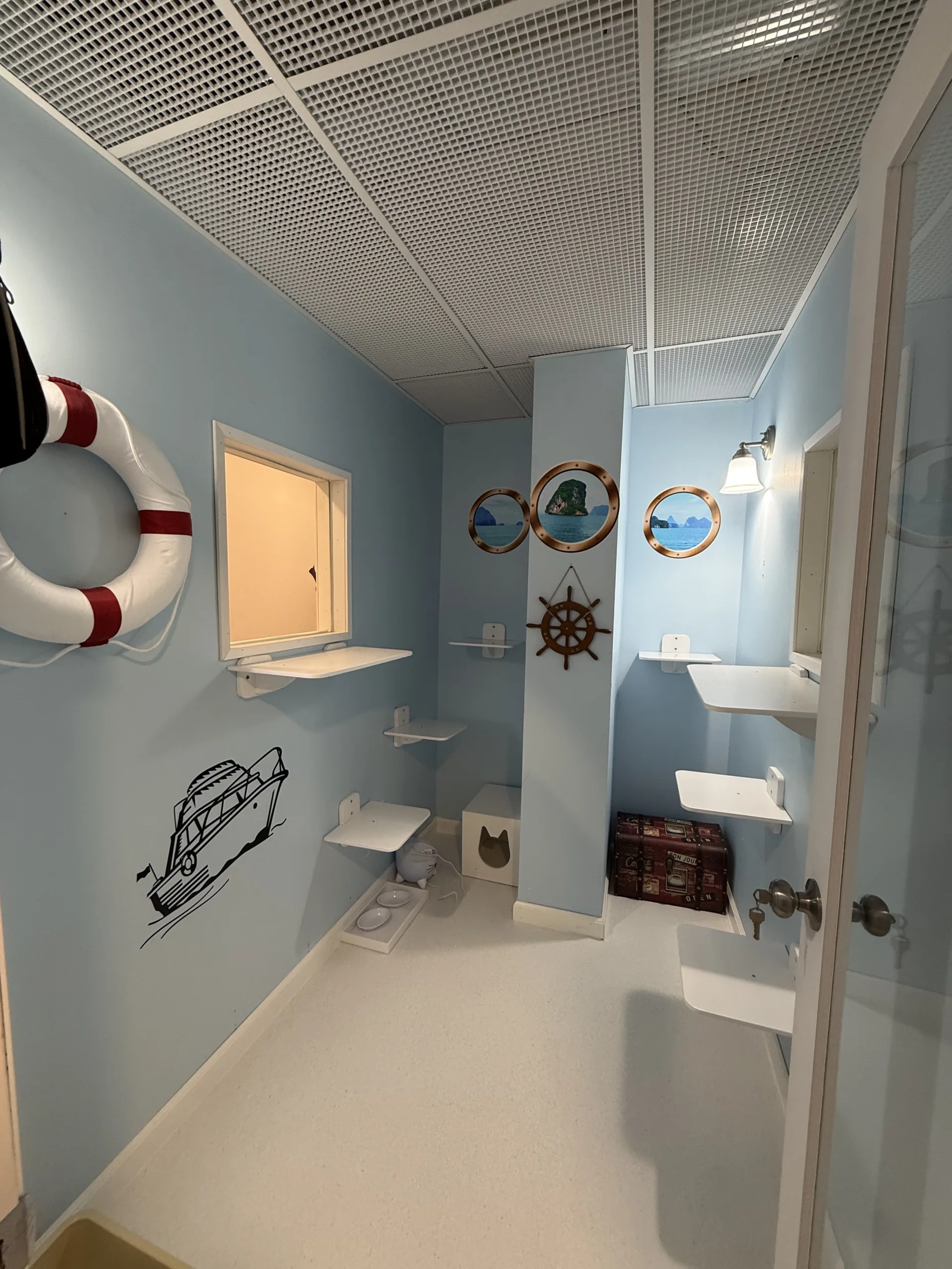Cats can enjoy a seaside-inspired stay in this nautical-themed suite complete with climbing shelves and cozy hideaways.