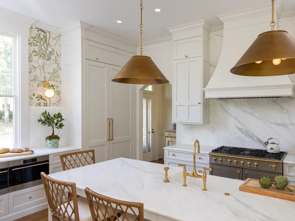 A bright and airy kitchen remodel featuring white cabinetry, floral wallpaper and gold accents.