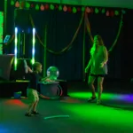 Mom and child dancing around and playing with dance party props