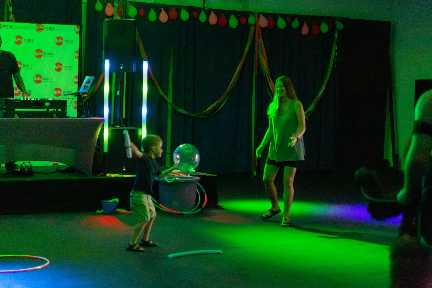 Mom and child dancing around and playing with dance party props