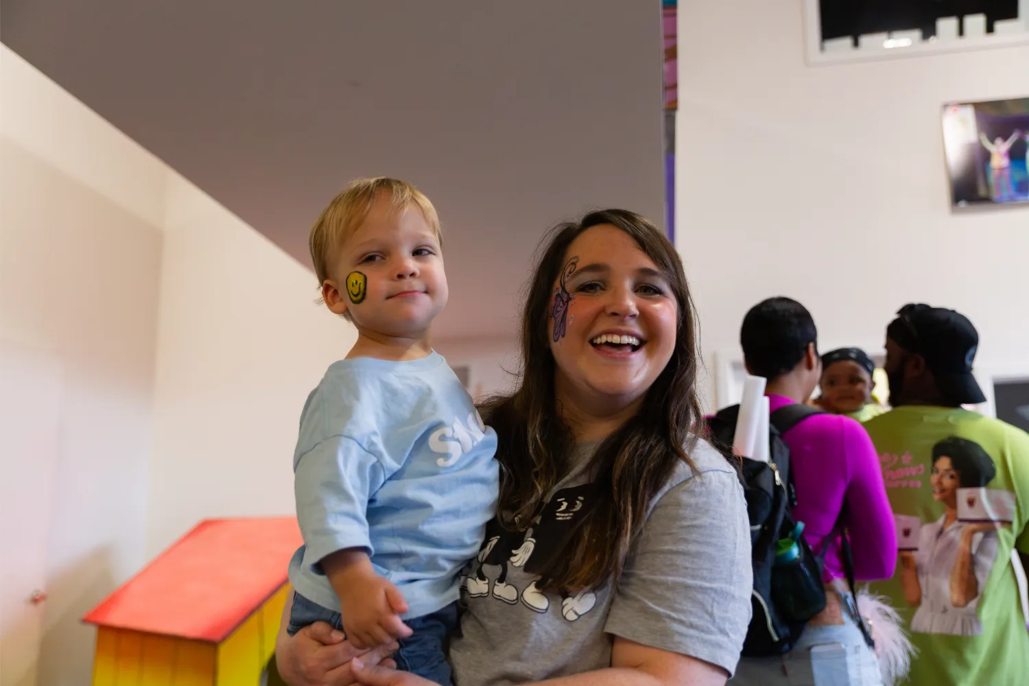 Mom and child smiling after getting some face paint