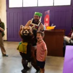 Child posing for a picture with the Romeo & Zooliet puppet
