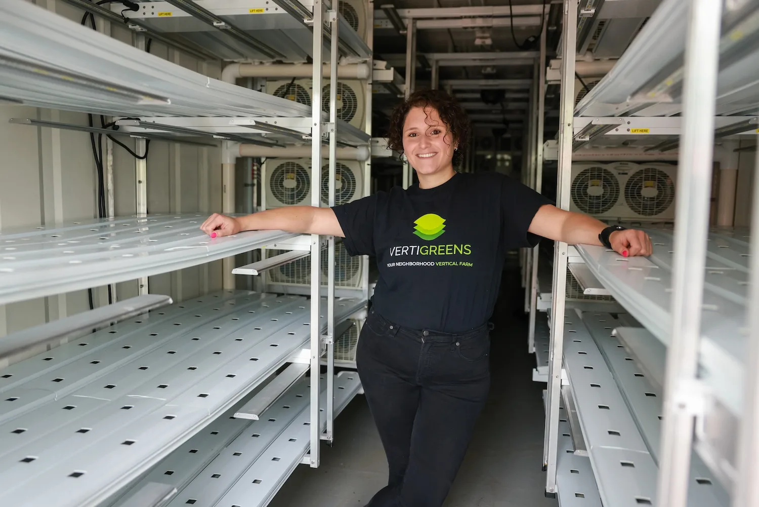 A woman stands inside a shipping container.
