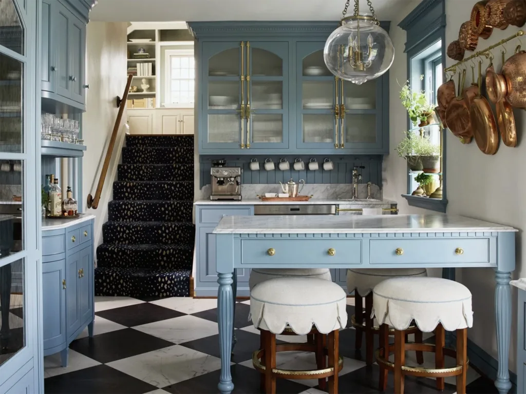 A kitchen remodel featuring light blue cabinetry, black and white diamond tiled floor and bronze accents.