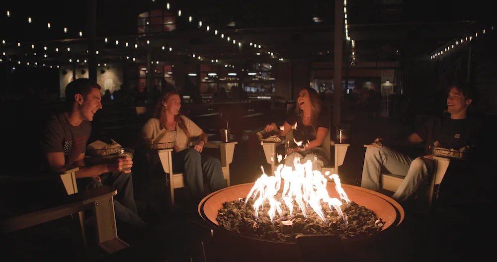 Guests gather around a fire at Old Glory Distilling Co.’s Silo Park.