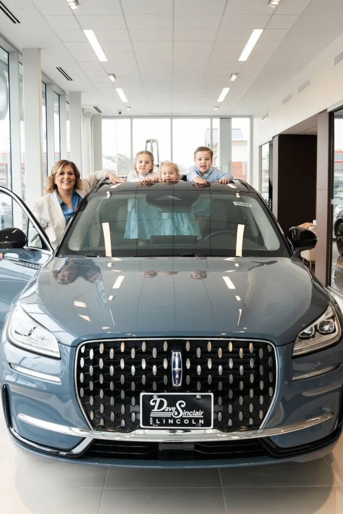 Megan Sinclair and her three children with a Lincoln at Dave Sinclair Lincoln.